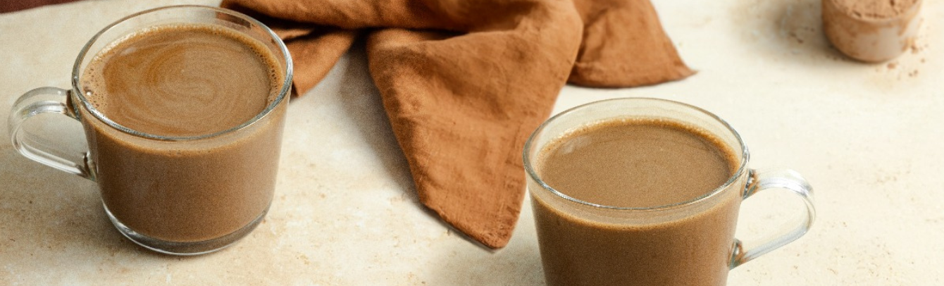hot-cocoa-in-two-clear-mugs-with-a-scoop-of-wellvine-cacao-powder